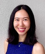 Portrait of Sarah Liu in sleeveless blue top, smiling against a light grey wall.